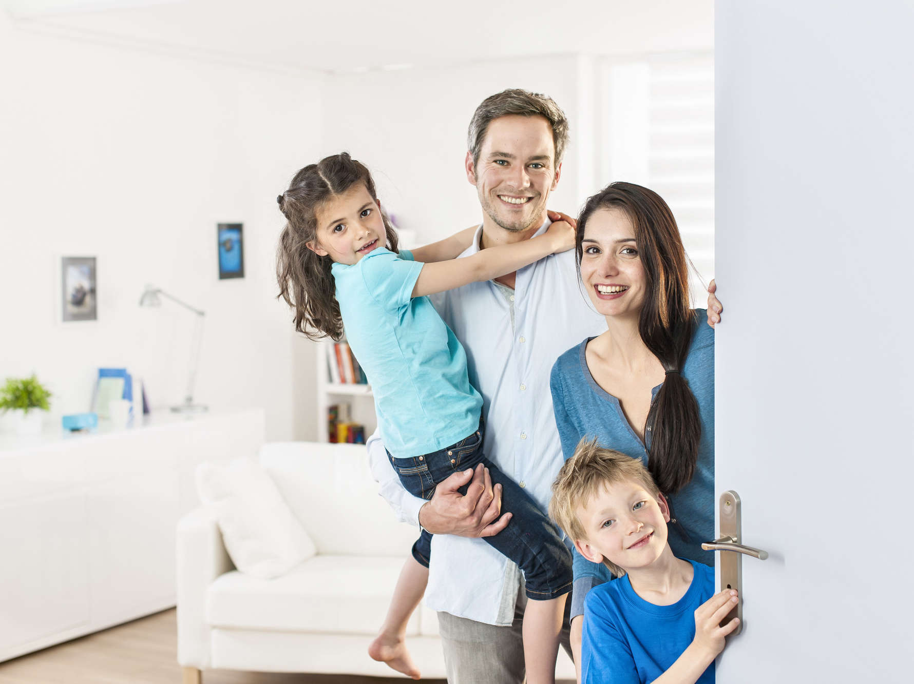 Family standing at front door to invite people at home